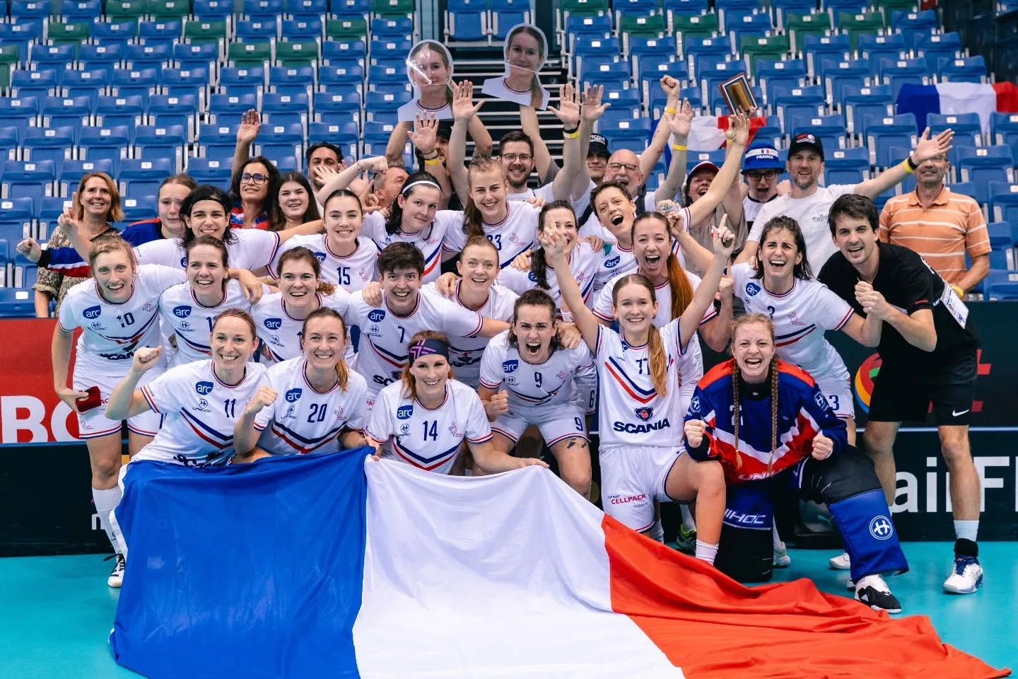 Équipe de France féminine de floorball célébrant avec le drapeau français au WFC 2023 à Singapour
